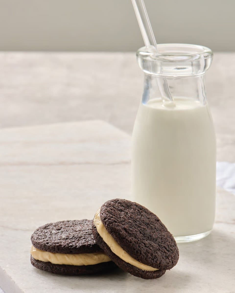 Chocolate Sandwich cookies next to a bottle of milk