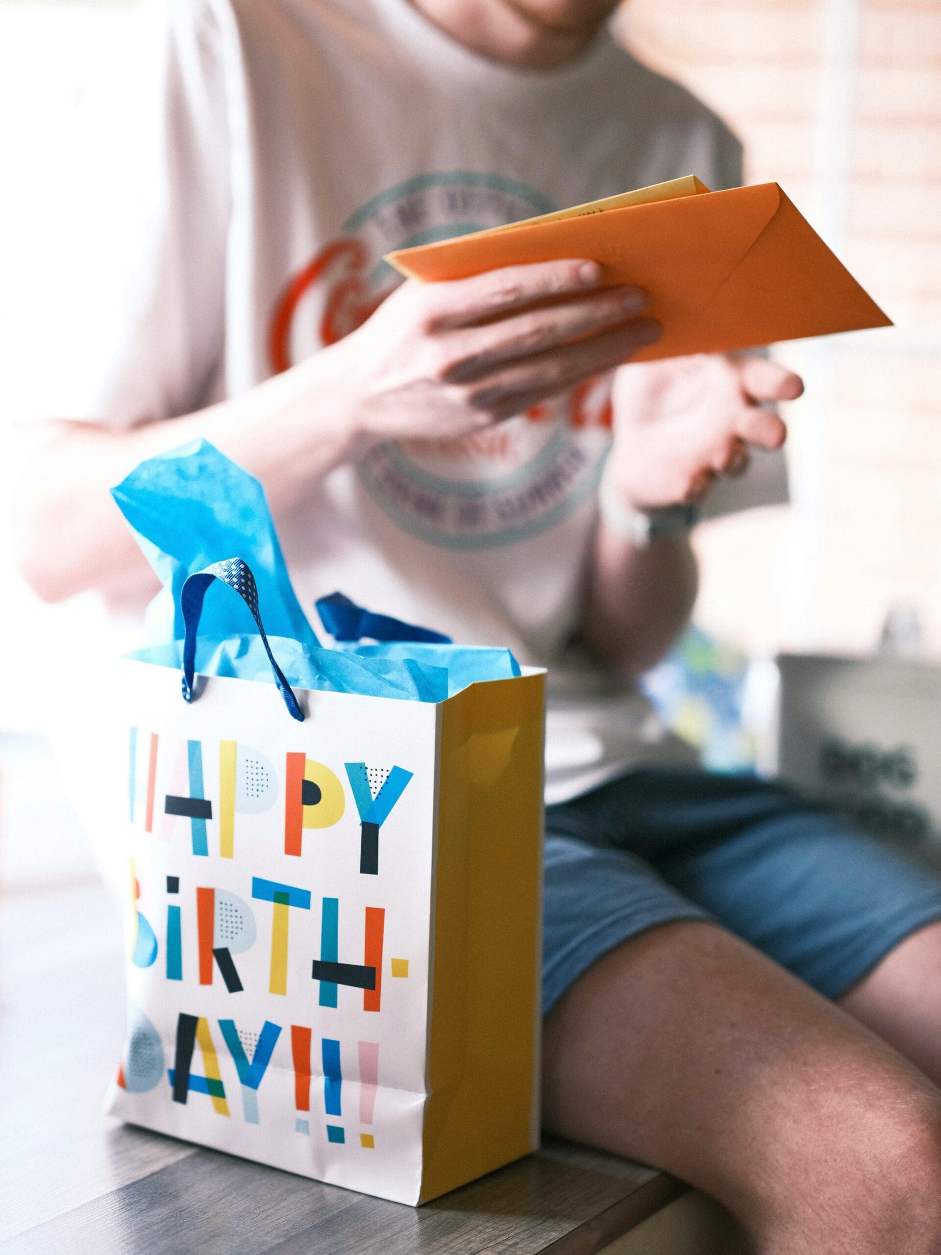 Teen boy opening a birthday gift and card