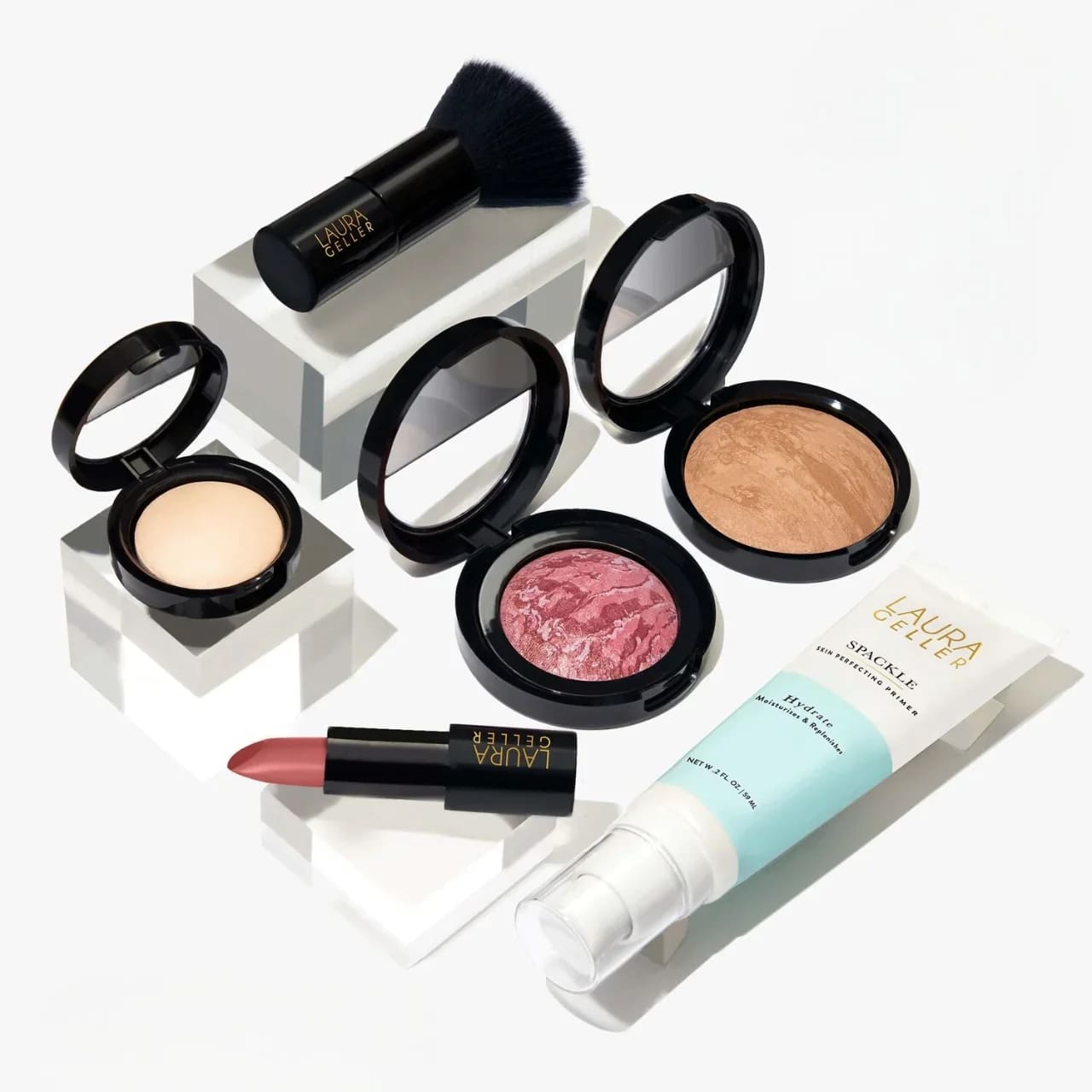 Laura Geller makeup kit: highlighter, brush, lipstick, blush, foundation, and primer